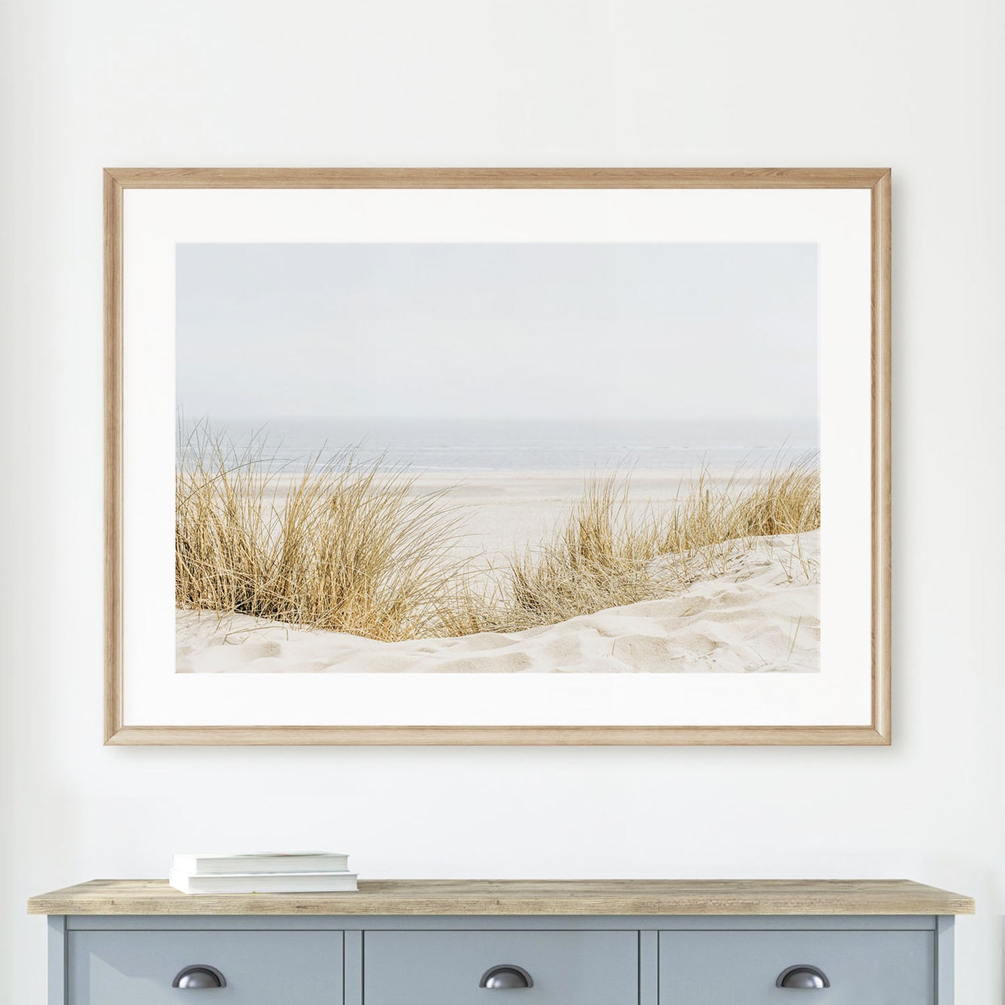 Minimalist coastal wall art print of sandy beach grass in a natural wood frame