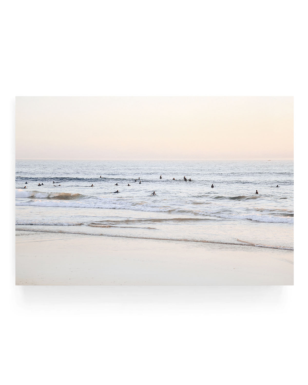 San Clemente surf wall art featuring surfers waiting in gentle ocean waves at sunset, with soft pastel sky tones and rolling waves along a sandy California shoreline.