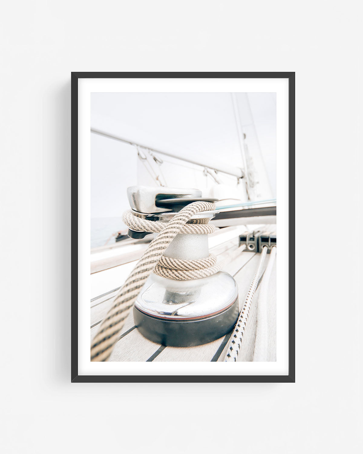 Fine art sailboat rope and winch photograph in a black frame featuring nautical deck details with coiled lines and soft coastal light.
