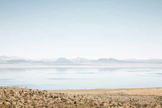 Mono Lake landscape photography featuring calm blue water, distant mountains, and golden high-desert sagebrush in California.