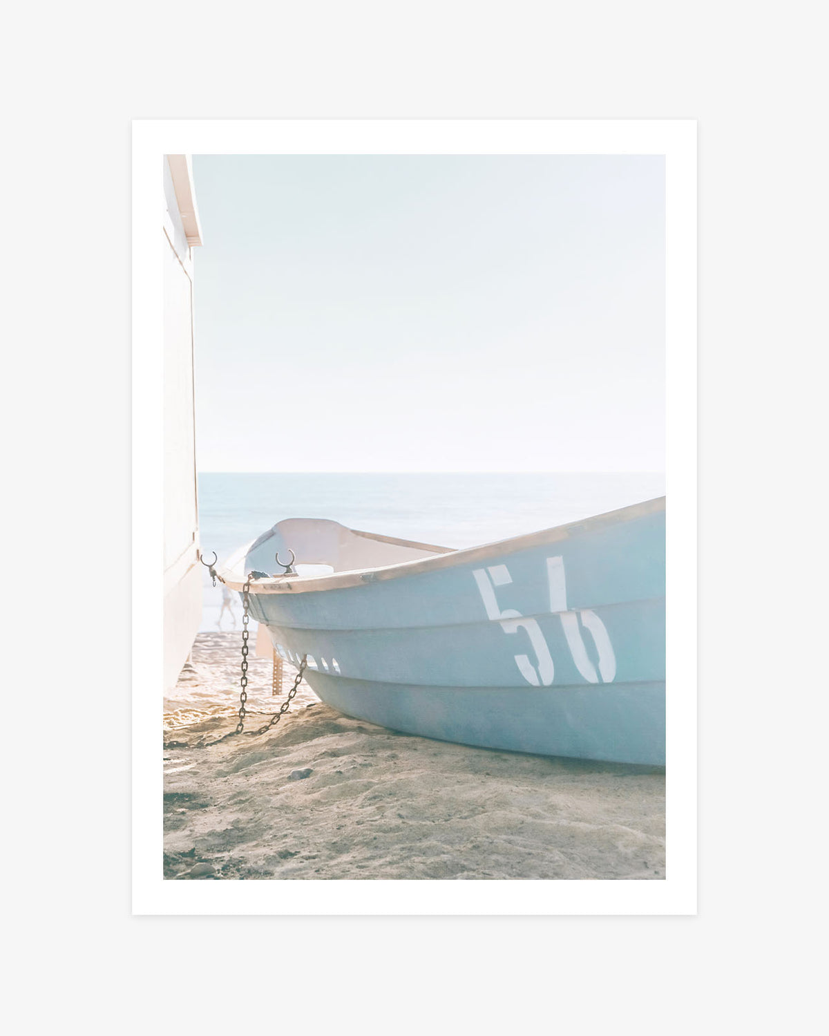 an Clemente beach wall art featuring a pale blue rescue boat marked 56 resting on the sand beside the Pacific Ocean.