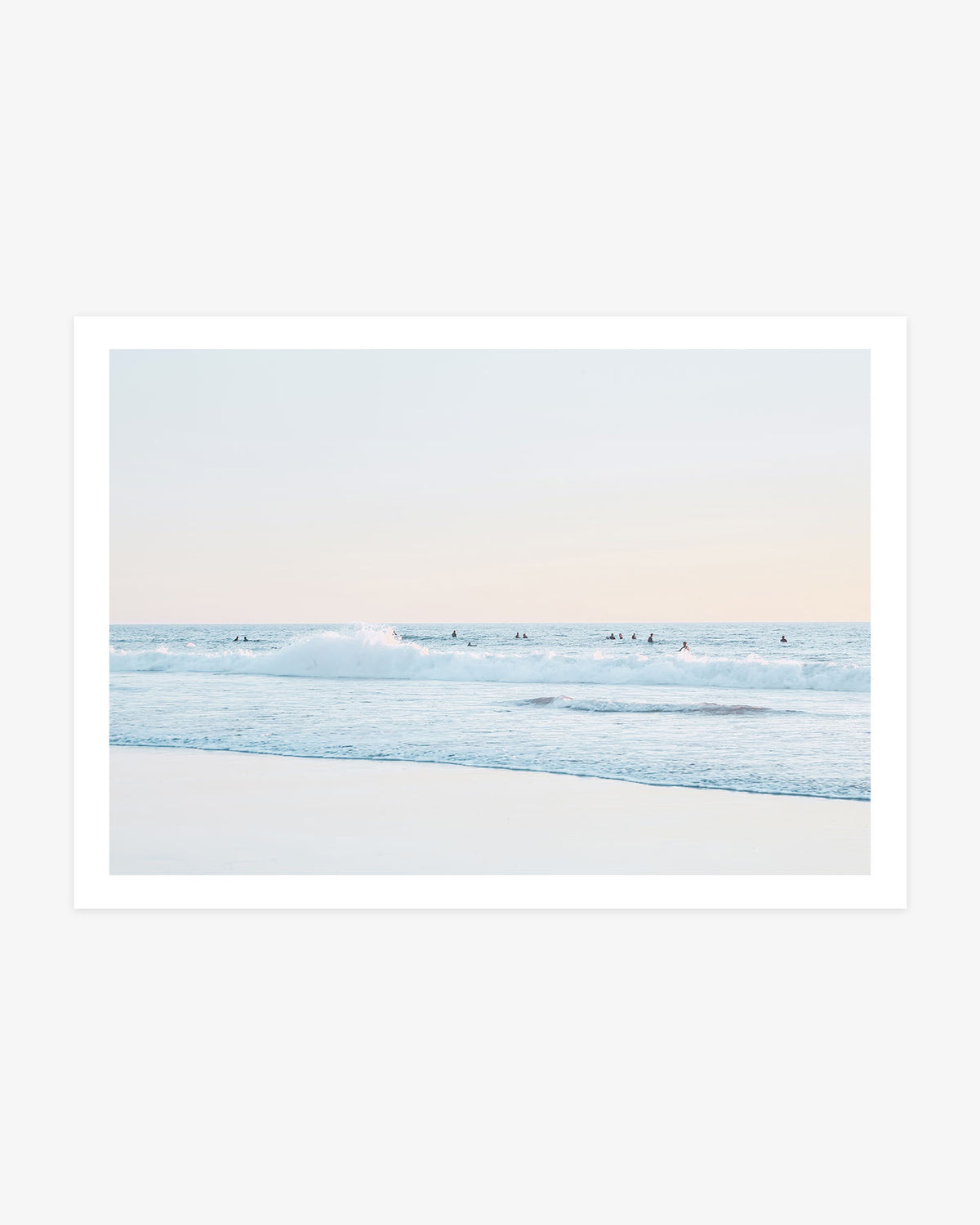 San Clemente surfer wall art featuring a distant lineup beyond a breaking Pacific wave beneath a pale blue and blush coastal sky.