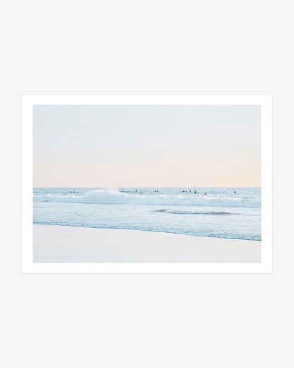 San Clemente surfer wall art featuring a distant lineup beyond a breaking Pacific wave beneath a pale blue and blush coastal sky.