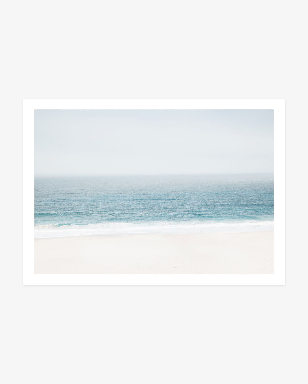 Pacific Ocean wall art featuring a soft blue horizon, gentle white surf and a pale sandy beach in calm neutral coastal tones.