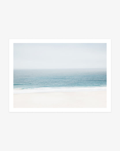 Pacific Ocean wall art featuring a soft blue horizon, gentle white surf and a pale sandy beach in calm neutral coastal tones.