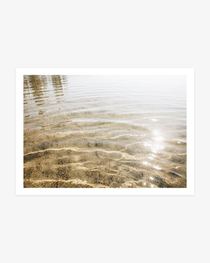 California lake photography featuring gentle ripples, clear shallow water and warm golden sunlight sparkling across the surface.