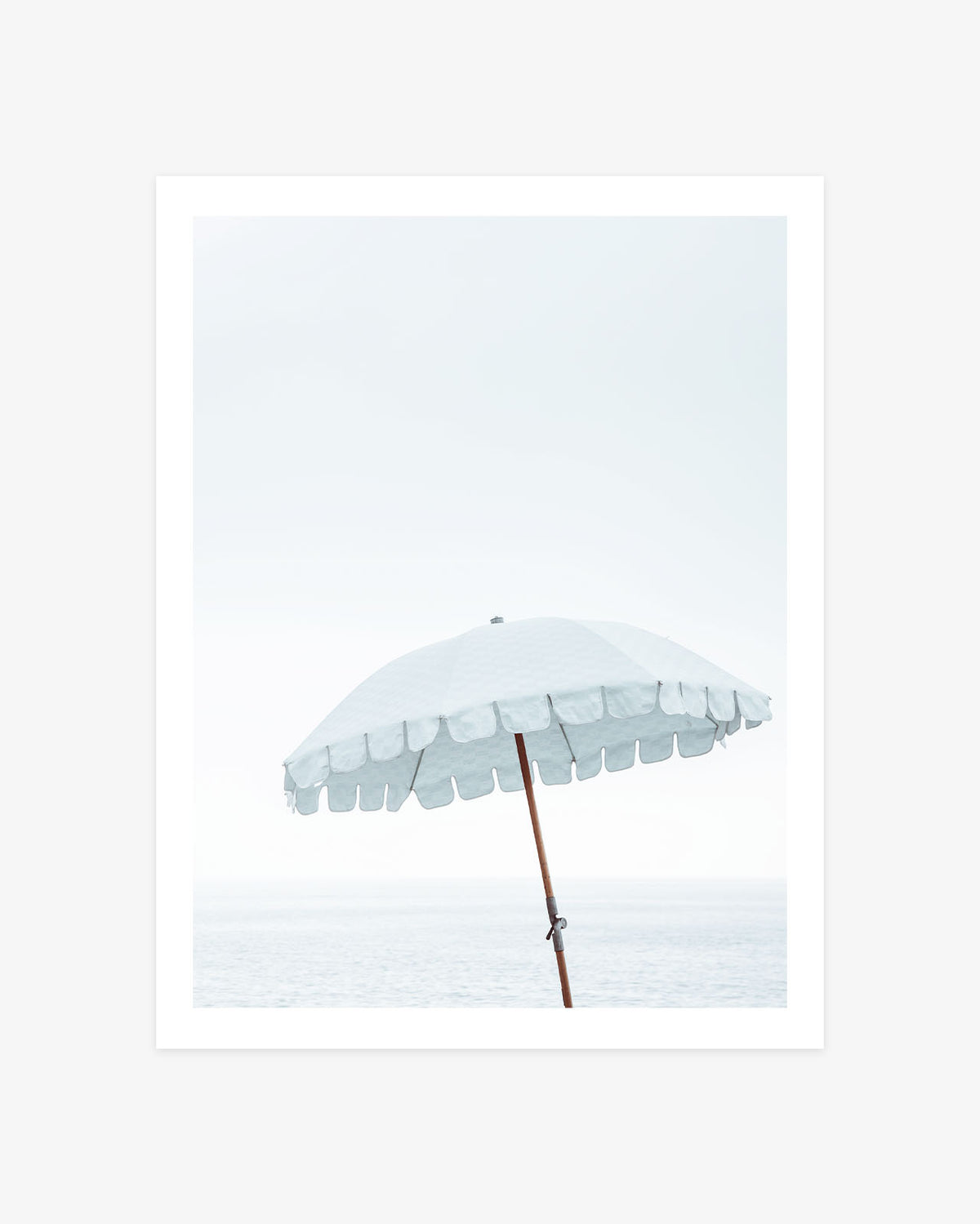 Malibu Beach umbrella photography featuring a pale blue scalloped parasol against a bright coastal sky and softly faded Pacific Ocean.