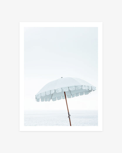 Malibu Beach umbrella photography featuring a pale blue scalloped parasol against a bright coastal sky and softly faded Pacific Ocean.