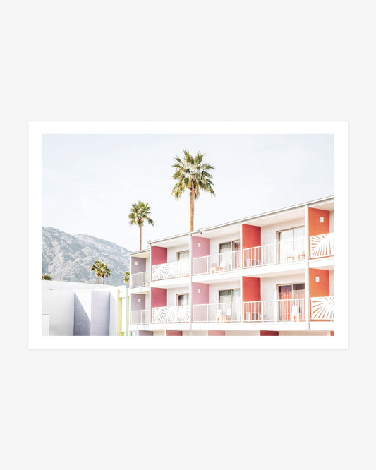 Colorful balconies at The Saguaro Palm Springs with tall palm trees and the San Jacinto Mountains in the background.