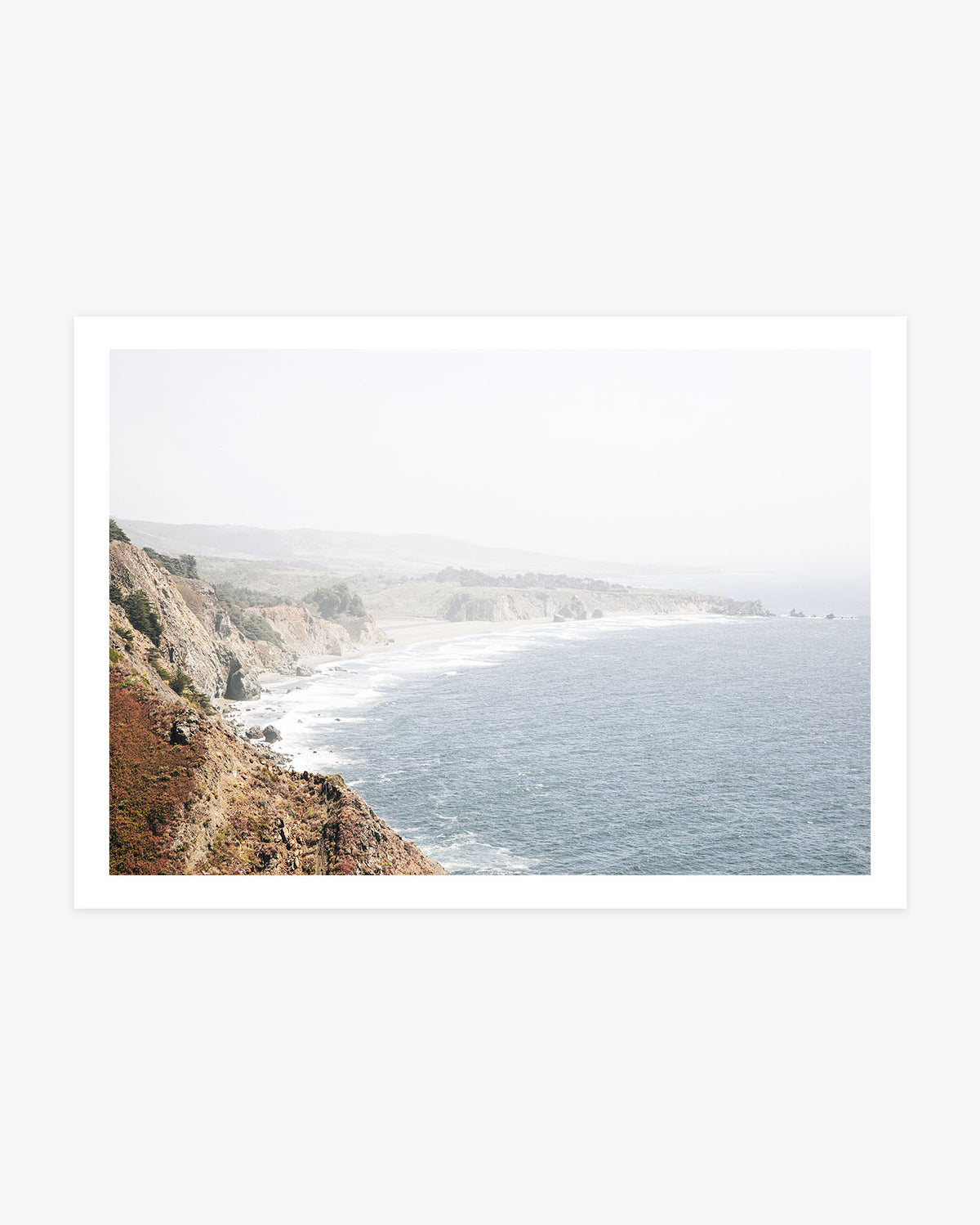 Big Sur landscape photography featuring rugged cliffs, secluded beaches and the blue Pacific coastline fading into soft California haze.
