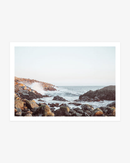 Dana Point coastal wall art featuring Pacific waves breaking through a rocky inlet beneath a pale blue Southern California sky
