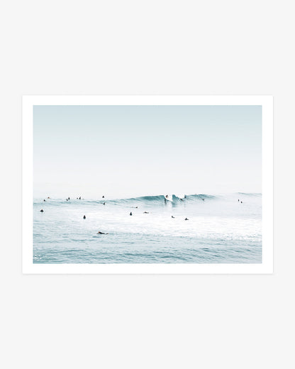 Huntington Beach surf wall art featuring two surfers riding a clean blue wave as others wait across the calm Pacific water.