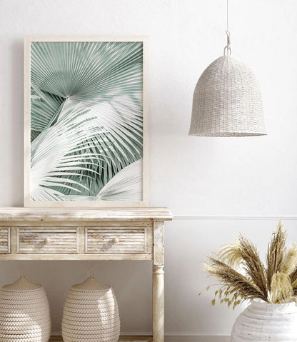 Framed boho palm tree wall art featuring soft mint green tones and tropical foliage in a minimalist coastal photography style, perfect for beach decor.