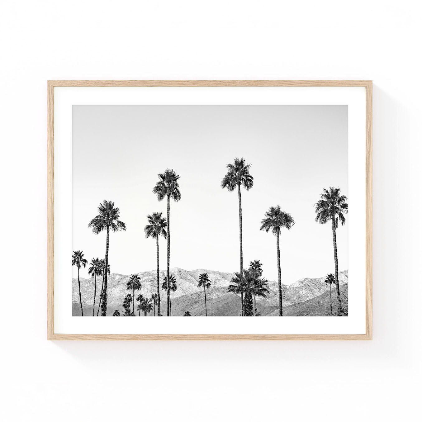 Black and white Palm Springs wall art featuring tall palm trees silhouetted against desert mountains, creating a timeless California landscape with modern minimalist appeal.