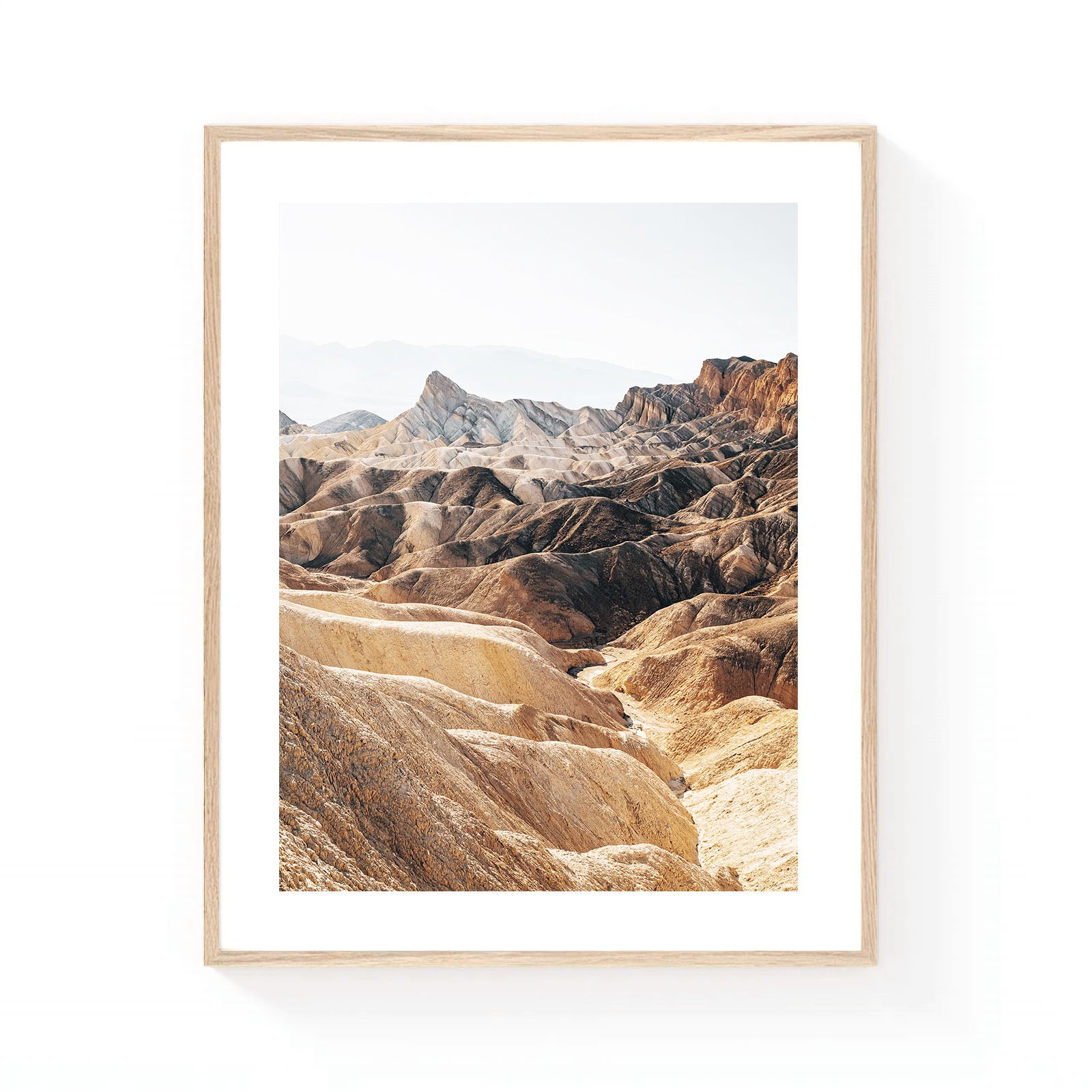Death Valley wall art featuring the layered badlands of Zabriskie Point in soft neutral tones, with sculpted desert ridges and dramatic geological formations.