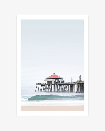 Huntington Beach Pier wall art featuring the former Ruby’s Diner above a turquoise wave beneath a soft, hazy California sky.