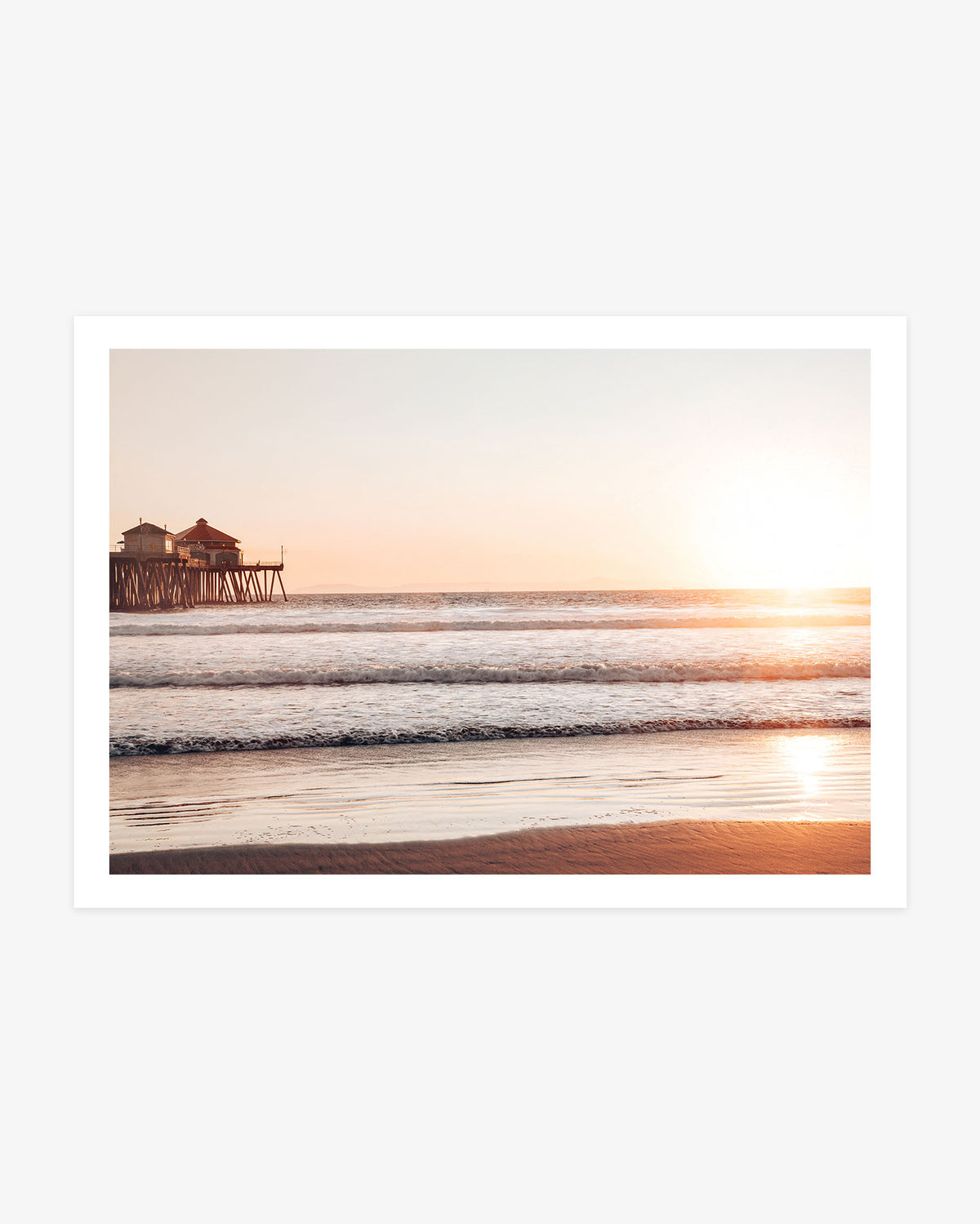 Huntington Beach Pier wall art featuring the former Ruby’s Diner, golden sunset light, ocean waves and reflections across the wet sand.
