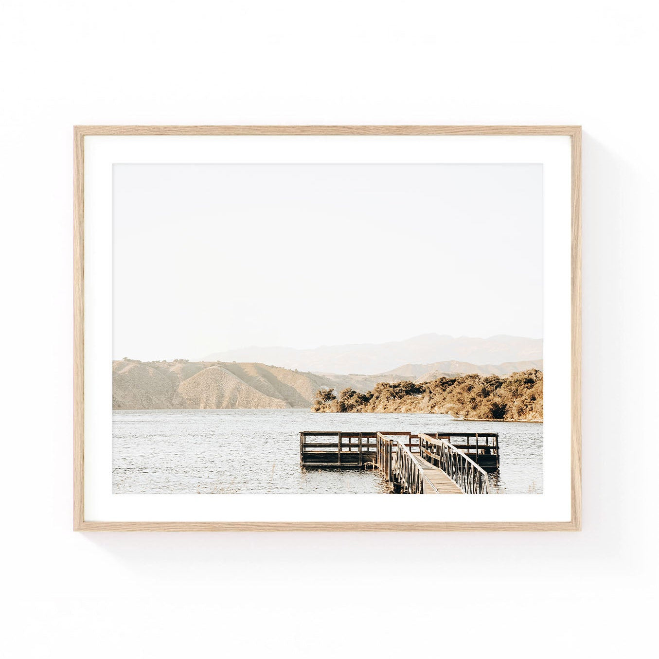 Lake Cachuma wall art featuring a rustic wooden dock extending into calm lake waters with rolling golden hills and soft mountain views in the distance.