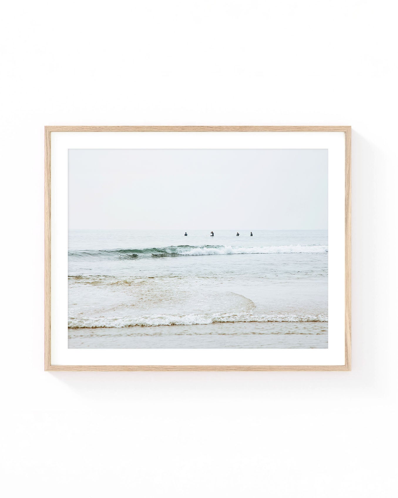 Malibu surfers wall art featuring four surfers waiting in calm Pacific Ocean waters beyond gentle rolling waves, with a soft horizon, muted coastal tones, and a serene Southern California beach atmosphere.
