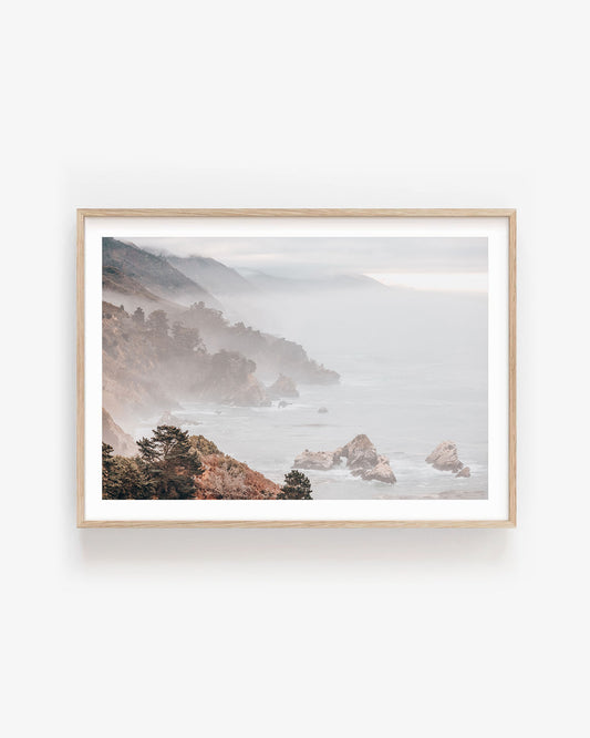 Misty Big Sur coastal landscape print featuring soft ocean cliffs, fog rolling over the shoreline, and muted blue tones for calming home wall decor.