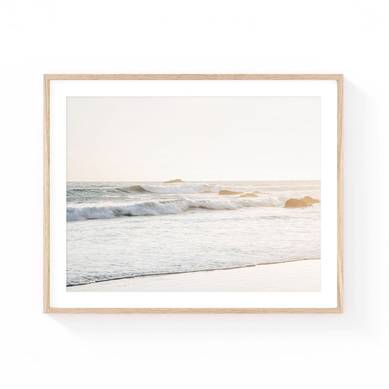Neutral ocean wave wall art featuring soft coastal waves rolling onto a sandy beach at sunset with warm golden light and gentle sea foam.