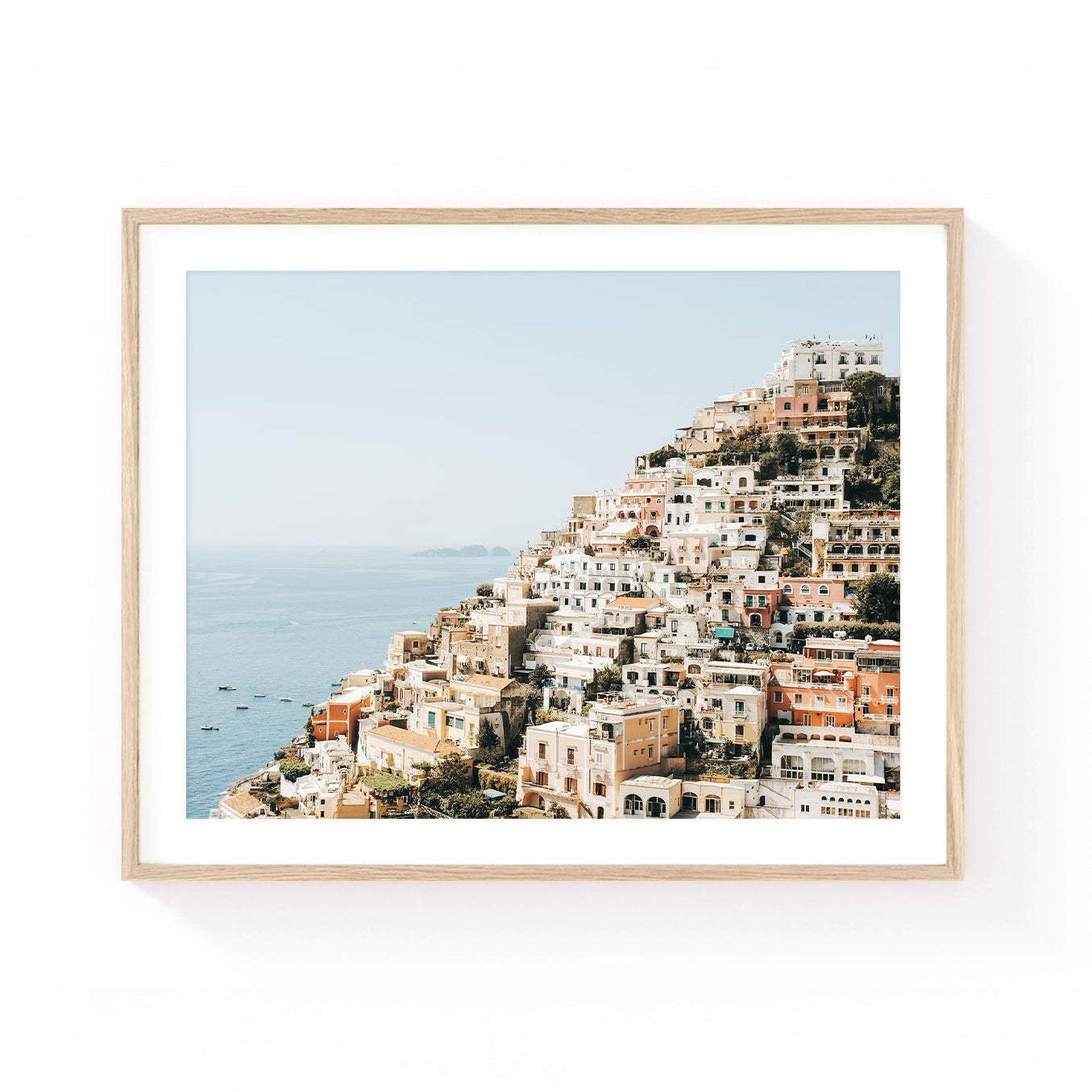 Positano wall art featuring colorful cliffside homes cascading down the Amalfi Coast above the Mediterranean Sea in soft sunlit tones.