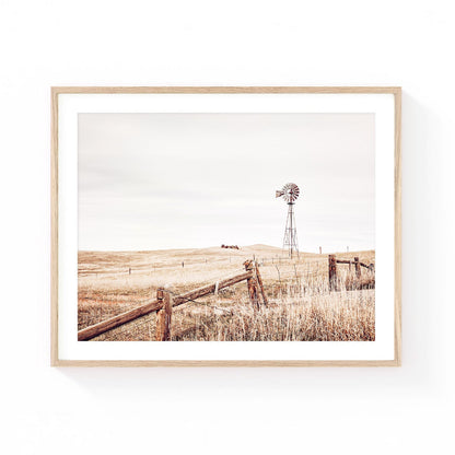 Rustic prairie wall art featuring a vintage windmill, weathered wooden fence, rolling grasslands, and wide open skies in soft neutral tones.