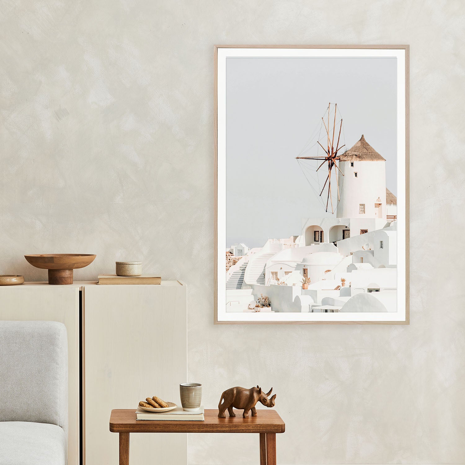 Framed Santorini Greece travel photography print hanging above sofa in living room