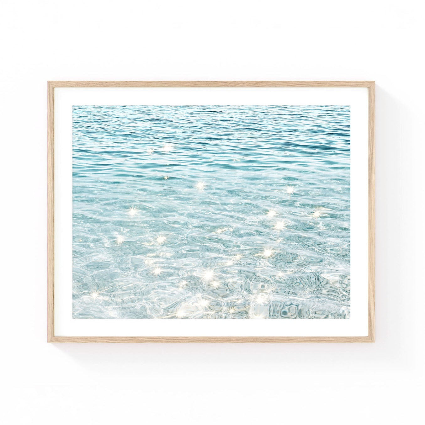 Ocean water wall art featuring crystal-clear turquoise water with shimmering sunlight reflections and soft coastal blue tones.