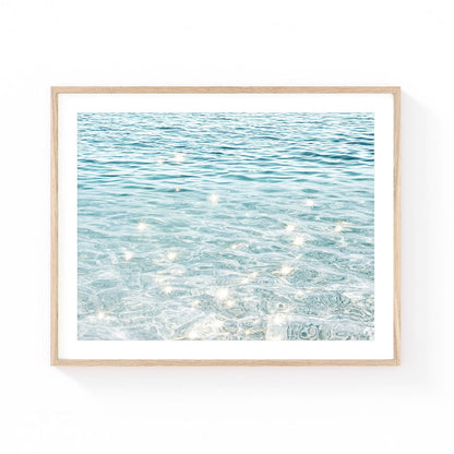 Ocean water wall art featuring crystal-clear turquoise water with shimmering sunlight reflections and soft coastal blue tones.