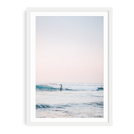 Fine art ocean wall art print of a surfer at sunset in a white frame with mat.