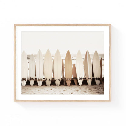 Surfboard wall art featuring a collection of vintage surfboards lined up on the beach with ocean waves and soft coastal tones.